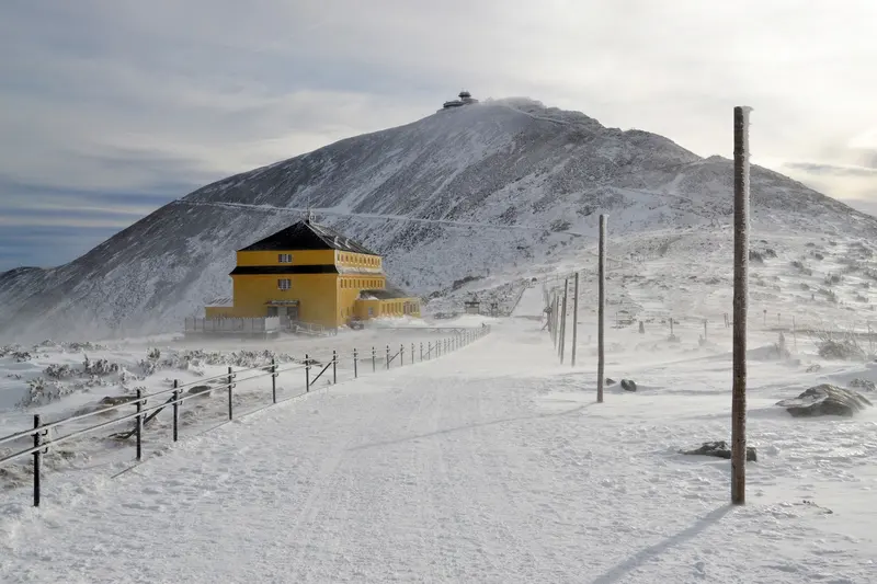 Ein verwehter Winterweg an der gelben Schlesischen Baude vorbei zum Gipfel der Schneekoppe